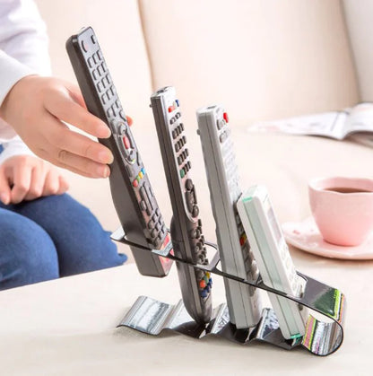 Remote control holder with multiple remote controls on a table.