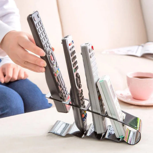 Remote control holder with multiple remote controls on a table.