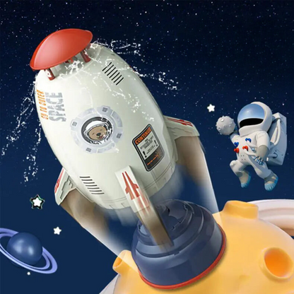 A toy rocket-shaped water sprinkler with a cartoon-like design, depicted in mid-air with water spraying from the top, surrounded by a space-themed backdrop with stars and a astronaut figure.