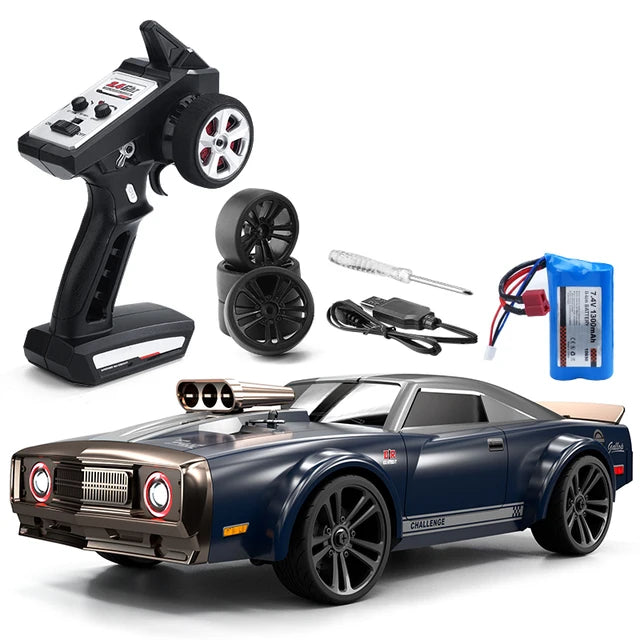 A collection of items including a black RC muscle car with brown accents, a remote control, a battery, and black wheels with tires, all spread out on a white background.